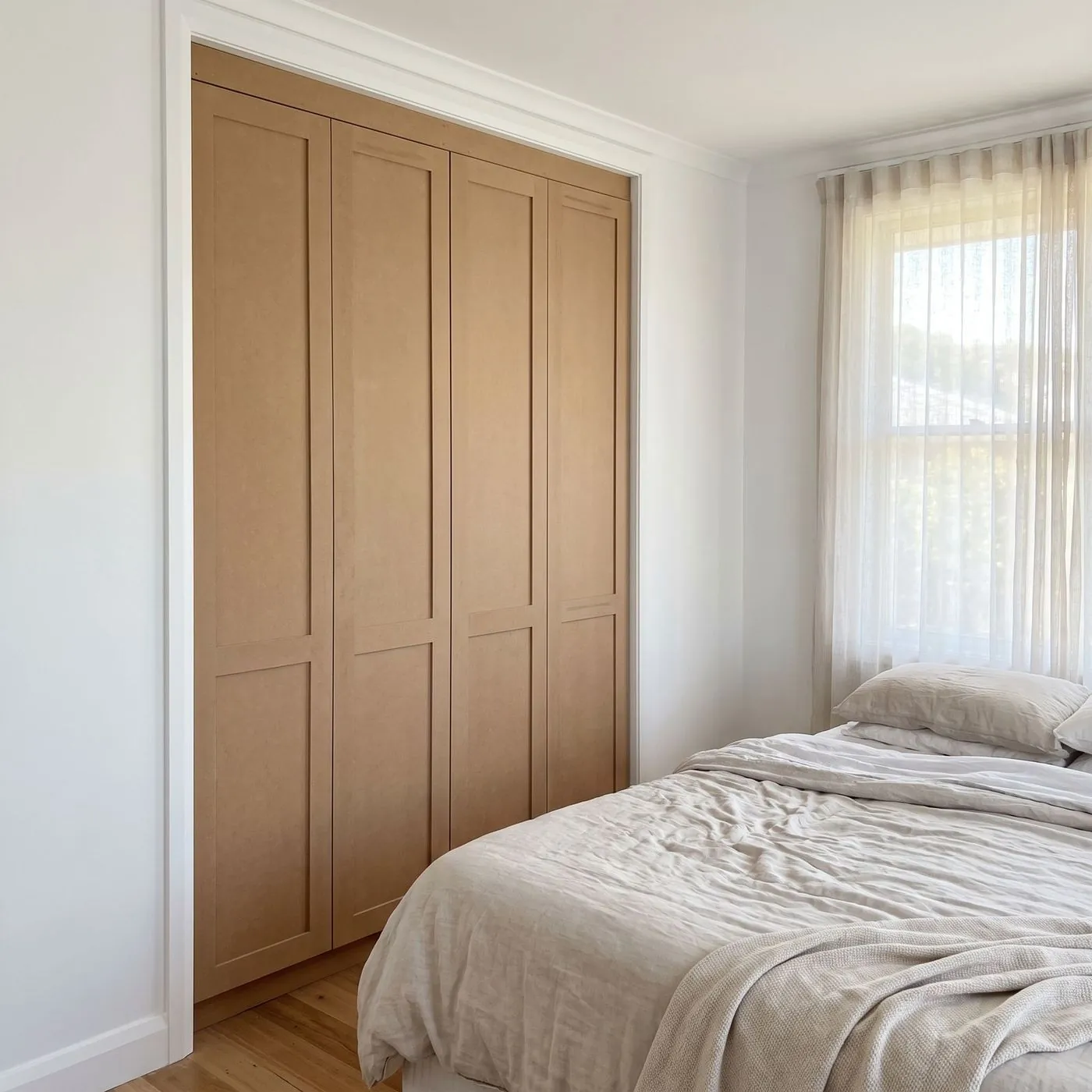 Built-in wardrobe with shaker-style hinged doors in a bedroom